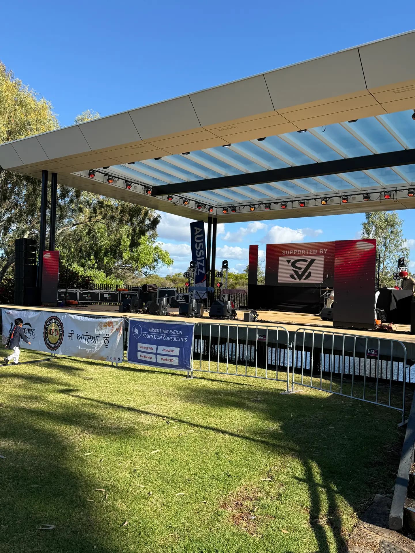 Outdoor community stage with an LED wall behind performers on a sunny day